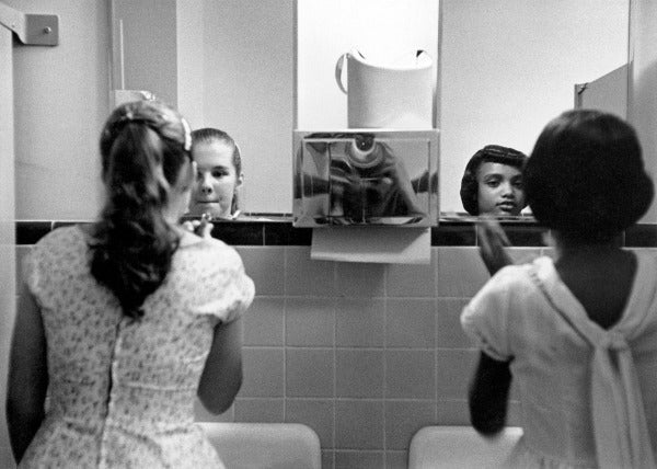 Eve Arnold: A Black Girl and a White Girl Make Up in the Ladies Room Before an Integration Dinner Party During the Civil Rights Strikes in America, 1958